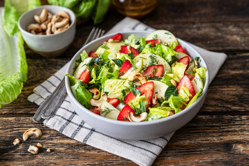 Fresh salad with lettuce leaves, apples, strawberries and cashew nuts	