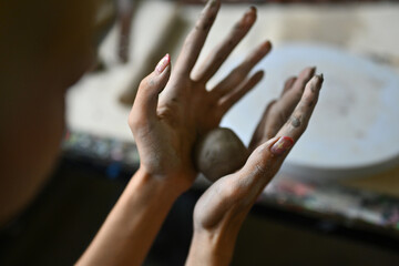 Close-up of an artist's hands gently molding clay, capturing the tactile experience and creativity...