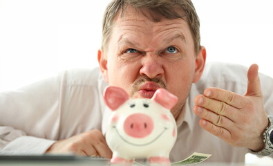 Funny businessman smelling scent of money from piggybank portrait