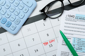 Tax day. Calendar with date reminder, document, pen, glasses and calculator on table, flat lay