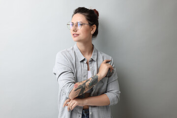 Portrait of beautiful tattooed woman on gray background
