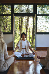 Young serene calm healthy Hispanic woman yoga coach meditating in studio doing breathing exercises...