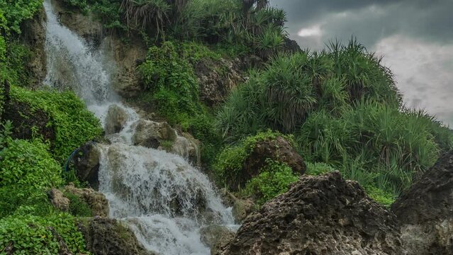 Bantul, December 3, 2022. Timelapse of Parang Endok Beach waterfall in the morning. the flow of this waterfall water directly to parangtitis beach