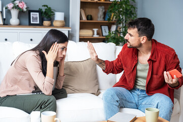 Young couple at home have a problem and argue due to jealousy caused by chatting and flirting via social media networks on smart phones, relationship difficulties problems and distrust