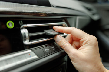 Woman hand adjusting air conditioner ventilation grille