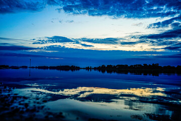 Wolkenspiegeln sich auf der glatten Weser in der Nähe von Brake