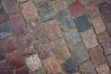 Background of a sidewalk made of square-shaped natural stone of light lilac, gray color.