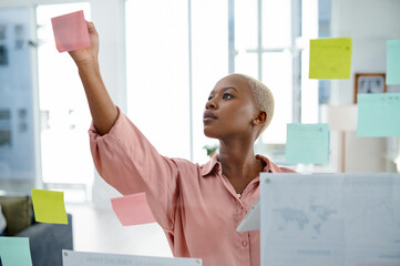 Glass, problem solving and sticky notes with business black woman in office for brainstorming or...