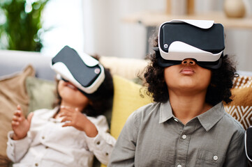 Virtual reality, kids and headset in living room with future technology, house and relax on sofa....