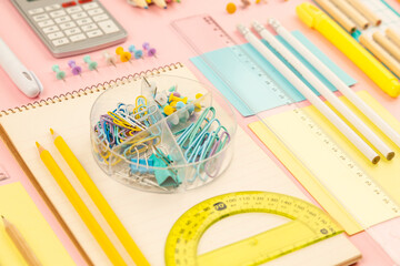 stationery items for girls or women on light pink. Back to school. Female Student's, pupil's or engineer's supplies. Office objects on pastel pink background. Calculator, pen, pencil etc. Copy space