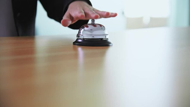 Businesswoman hand using a hotel bell