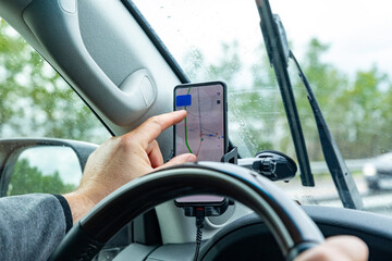 Hand of driver with smartphone, use Navi map and drive a car. Selective focus, GPS in a city concept
