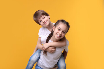 Happy brother and sister on orange background