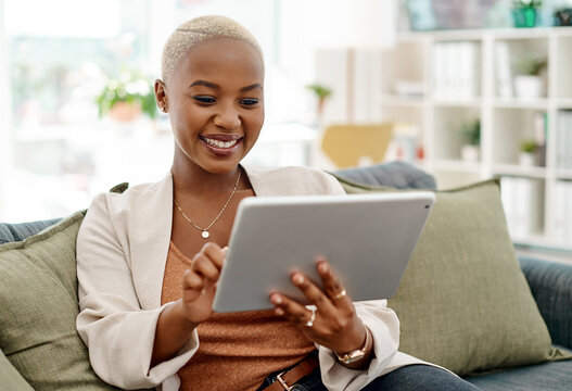 Tablet, happy and black woman on couch for communication, research or funny review in modern office. Female assistant, digital technology and scrolling on sofa for social media, contact or networking