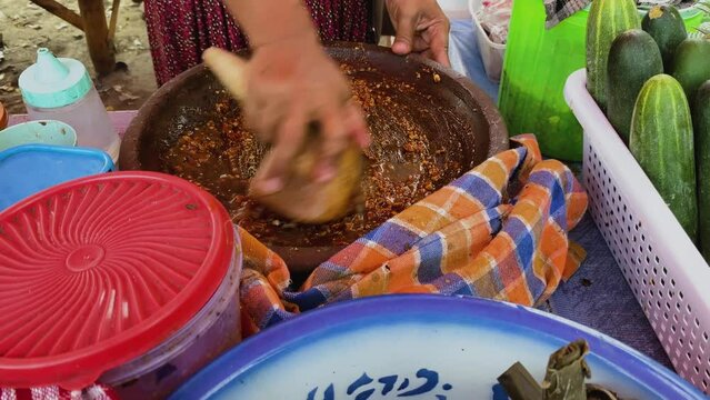 Preparing rujak petis. Rujak petis is traditional food from Java made from steamed mix vegetables, black sauce made from fried garlic, chillies, petis (black fermented shrimp paste) and ground peanuts