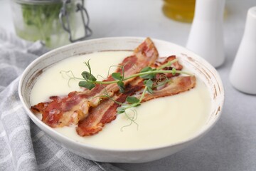 Delicious potato soup with bacon and microgreens on grey table, closeup