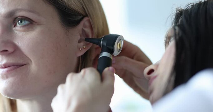 ENT diagnosis and examination of the ear with otoscope of woman. Problem and hearing impairment in adult concept