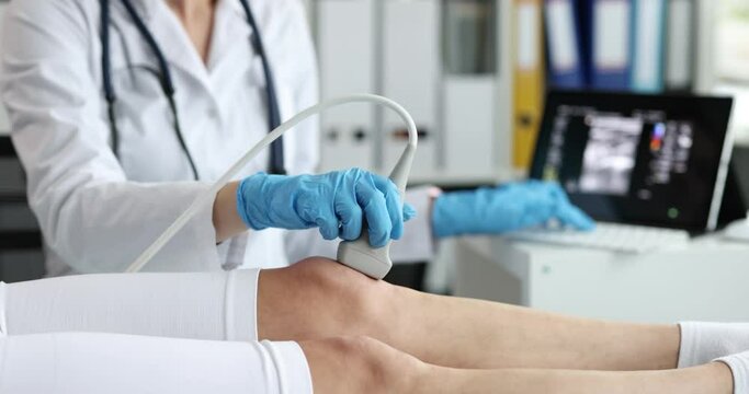Orthopedic doctor makes ultrasound examination of patient knee in office. Knee pain causes and treatment concept