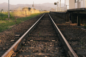 Fototapeta premium 夕暮れせまる景色の中真っ直ぐ伸びる線路