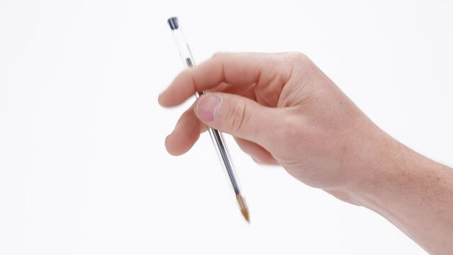 A caucasian male hand stimming and fidgeting quickly with a pen, suggesting ADHD, autism, nervousness, or anxiety. Captured isolated against a plain white background. 