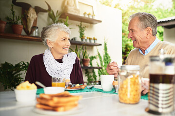 Happy, senior couple and eating breakfast together with fruit for discussion about retirement,...