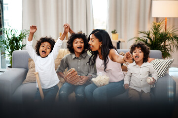 Family, baseball game and living room with cheer, popcorn and happy with sports for bonding. Childhood, memories and team victory with smile, celebration and arms raised with siblings in home. - Powered by Adobe