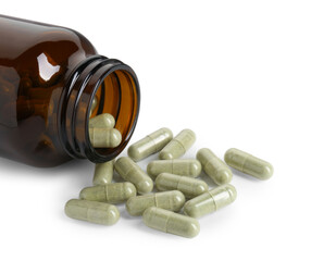 Scattered vitamin capsules and bottle isolated on white