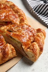 Cut delicious homemade pie on light grey table, closeup