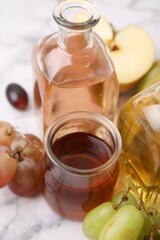 Different types of vinegar and ingredients on light table, closeup