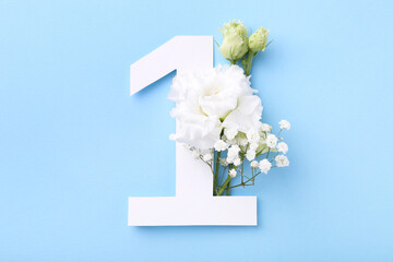 Paper number 1 and beautiful flowers on light blue background, top view