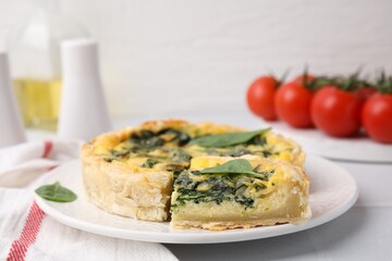 Delicious pie with spinach on white tiled table