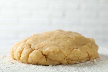 Making shortcrust pastry. Raw dough and flour on table, closeup