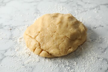 Making shortcrust pastry. Raw dough and flour on white marble table
