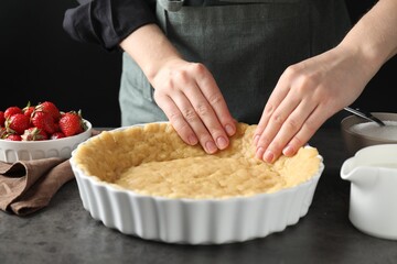 Shortcrust pastry. Woman making pie at grey table, closeup