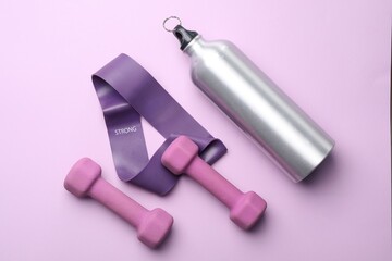 Two dumbbells, fitness elastic band and thermo bottle on violet background, flat lay