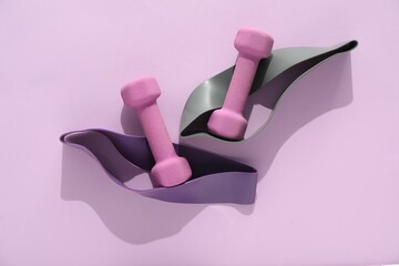 Dumbbells and fitness elastic bands on violet background, flat lay