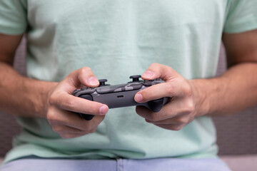 Man plays video games. Close-up of male hands holds joystick. Leisure time and gamer concept	