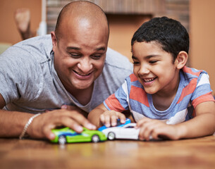 Father, son and playing with toy car for love, relationship in home as family in bonding. Man, boy...