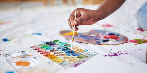Mixing paint, hand and paintbrush with colors for art, picture and creation in studio. Artists...