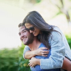 Couple, piggy back and smile at park in summer with nature, holiday or playful adventure with love....