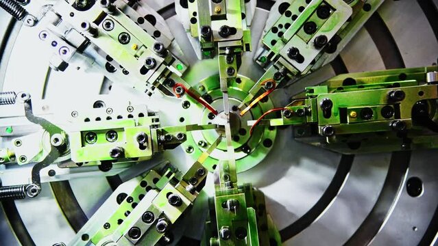 Close up of metal spring manufacturing machine at work