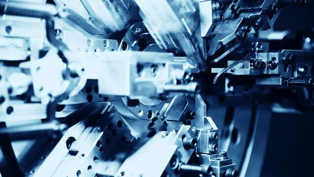 Close up of metal spring manufacturing machine at work