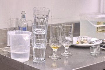A bunch of dirty glasses and plates piled up in a restaurant kitchen