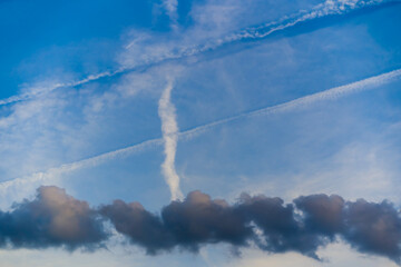 Bizarre sky sight with clouds and trails of planes