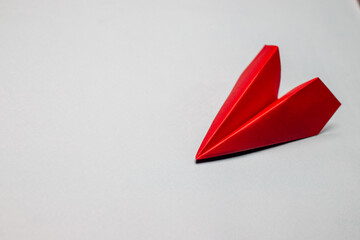 Red paper plane on a light grey background concept motivation aviation