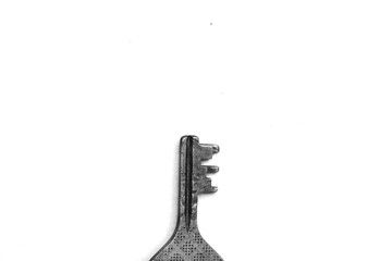 A metal key on a white background black and white photo motivation 