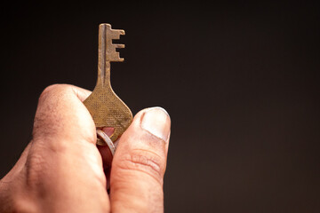 A metal key in hand on a dark background motivation inspirtation destiny