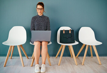 Business woman, laptop and waiting room for recruitment, hiring and job search on human resources...