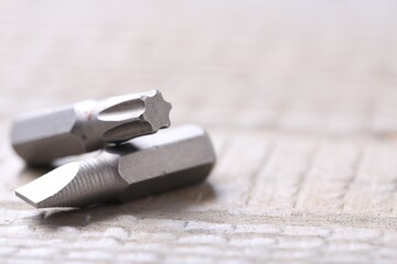 Different screwdriver bits on wooden table, closeup. Space for text