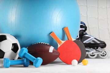 Many different sports equipment on white table